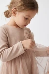 Tüdrukute pidulik kleit Iga beež – tüllvibu rinnal ja trikotaažist pikk varrukas, lähivõte küljelt